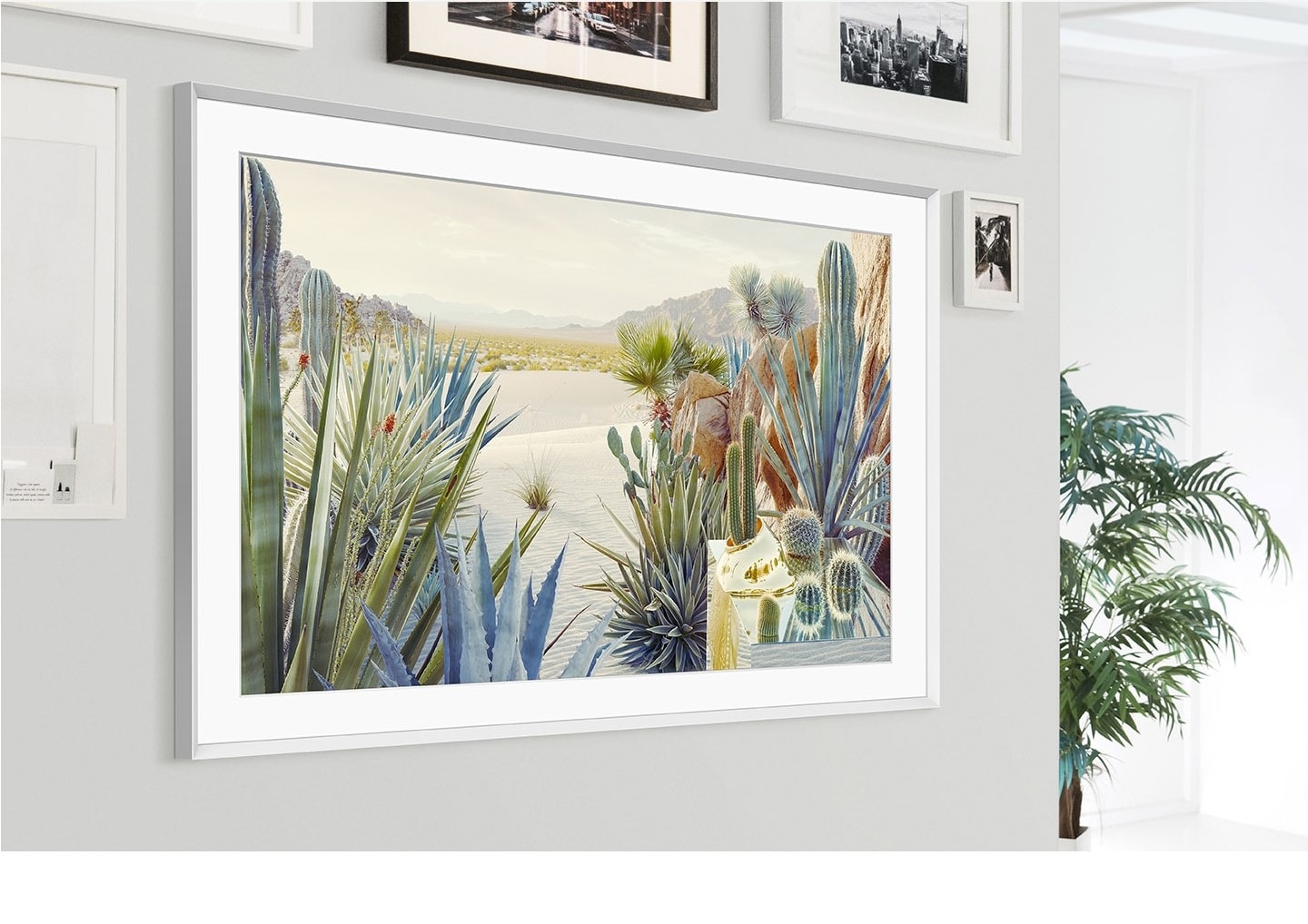 The Frame is mounted on the wall of a home interior and its modern frame design blends with the other picture frameson the wall.