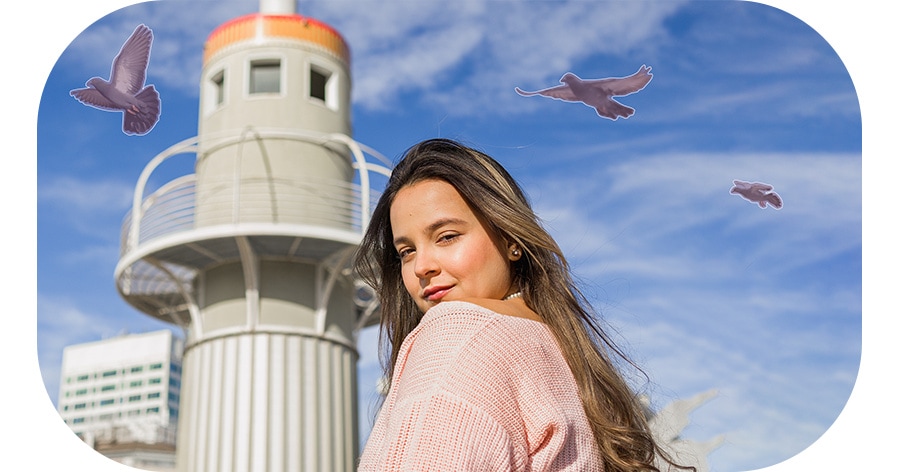 A portrait shot of a woman looking back at the camera with a bird flying in the blue sky background. As Object Eraser is applied, the bird is erased from the background.