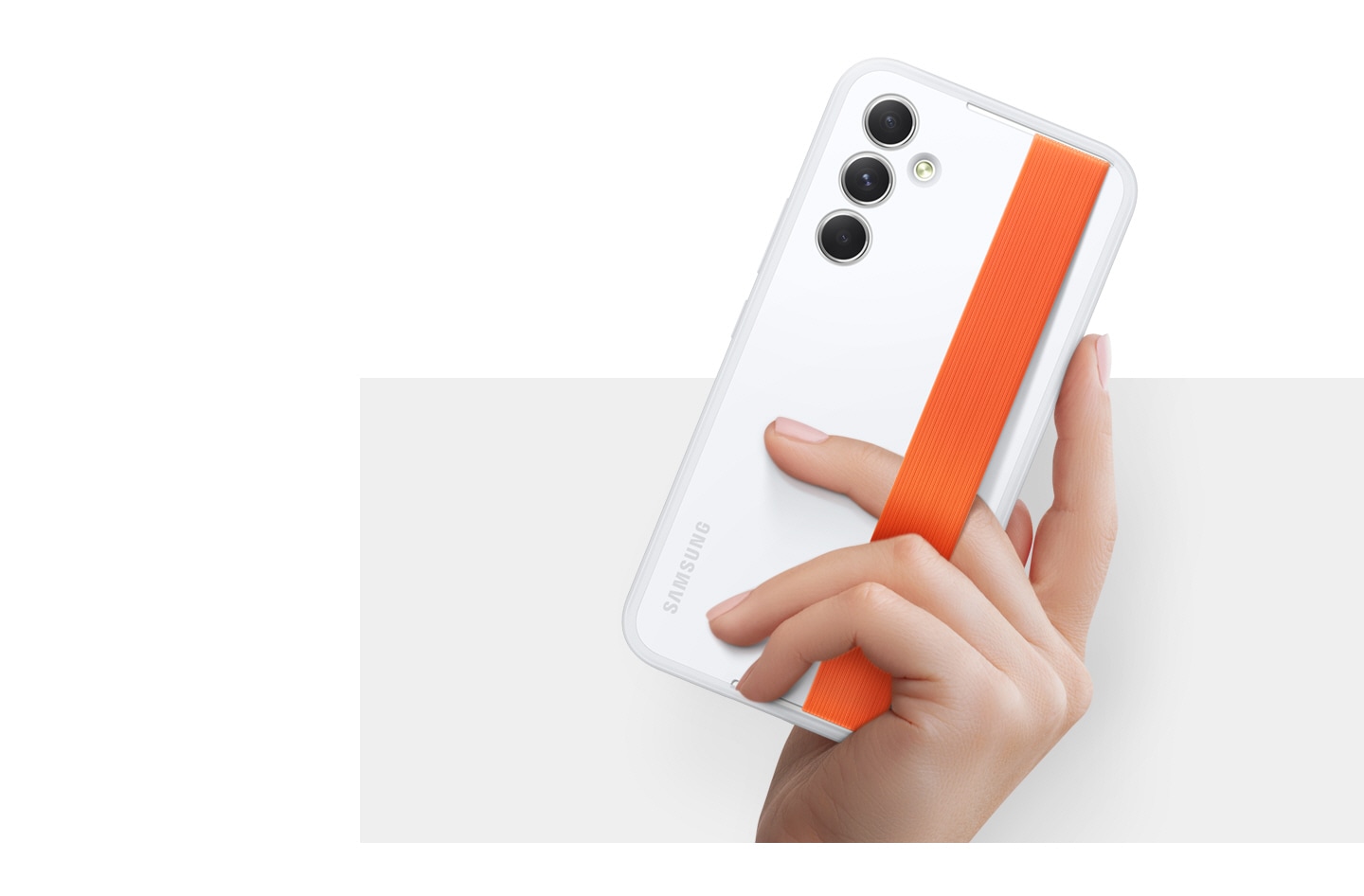A hand holds up a Galaxy device wearing a white Haze Grip Case with an orange strap.
