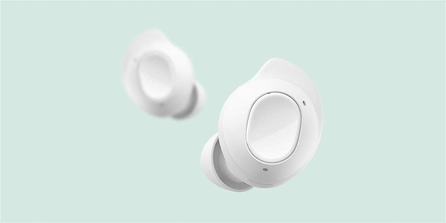 Two earbuds of Galaxy Buds FE are shown, with one placed in front of the other. The touch area of the buds is highlighted. The two earbuds switch places. The grip area on the outer surface is highlighted.