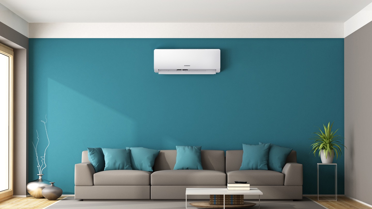 Shows the air conditioner mounted on a wall above a sofa in a stylish and modern looking living room.