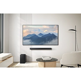 B650F soundbar placed beneath a TV in a living room. A subwoofer is placed on the floor too.