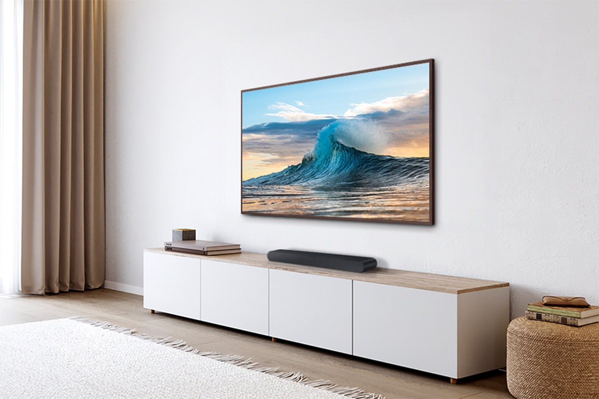 A Samsung TV on the wall and Samsung Soundbar S60D on a console stand.