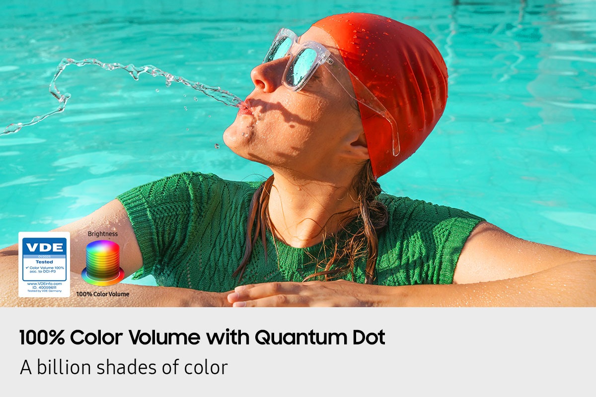 A scene of a woman in a pool spitting out water. Logo reads VDE 01/2025 Tested Color Volume 100% acc. to DCI-P3. www.VDEinfo.com. ID 40059611. Tested by VDE Germany. Another logo is made of stacked color wheels that represent Brightness.