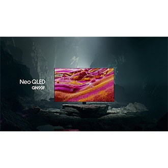 Samsung Neo QLED QN90F TV in a black and white underground space displays a colorful scene of an otherworldly landscape.