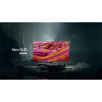 Samsung Neo QLED QN90F TV in a black and white underground space displays a colorful scene of an otherworldly landscape.
