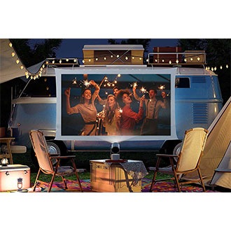 The Freestyle that's attached to a Battery Base is projecting an image on a campsite.