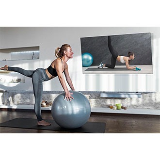 Woman exercising with  articulating TV mount.