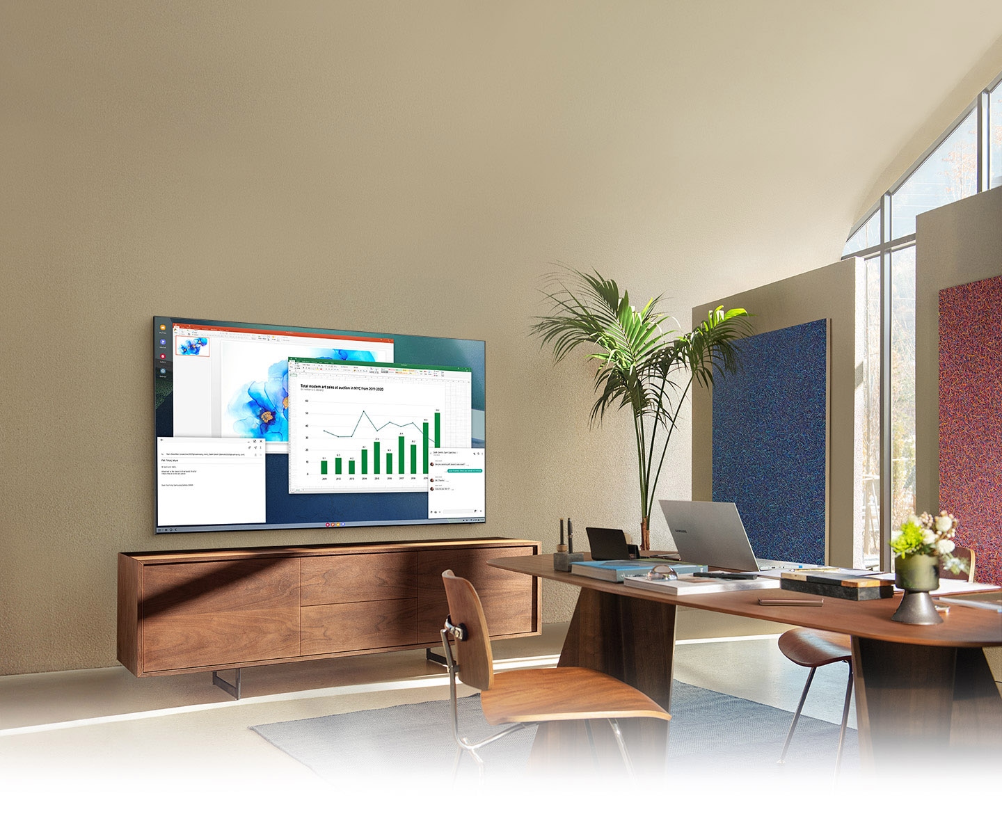 In a living room home office, QLED TV screen shows PC on TV feature which allows home TV to connect to office PC.