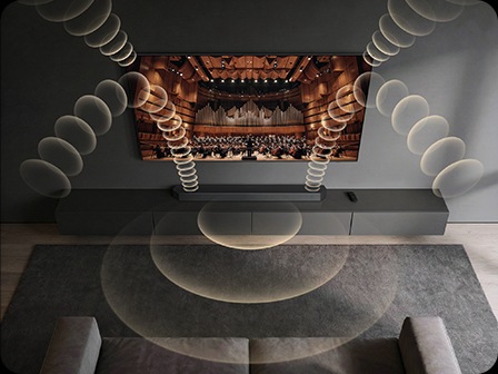 A Samsung TV and soundbar play a concert hall scene, with layered sound waves illustrating Q-Symphony synchronizing speakers for fuller audio.