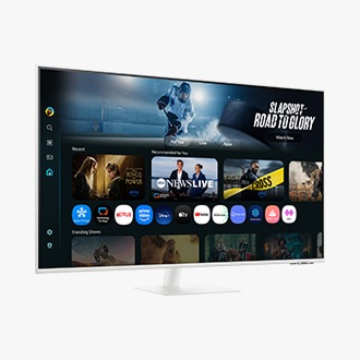 Front-left perspective of 43 inch Samsung Smart Monitor M7. Screen showing Smart TV Apps page with various content and apps lined up.