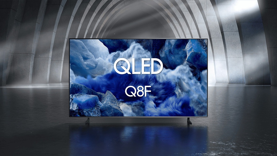 Samsung QLED Q8F TV in a black and white indoor space displays a colorful scene of an otherworldly landscape.