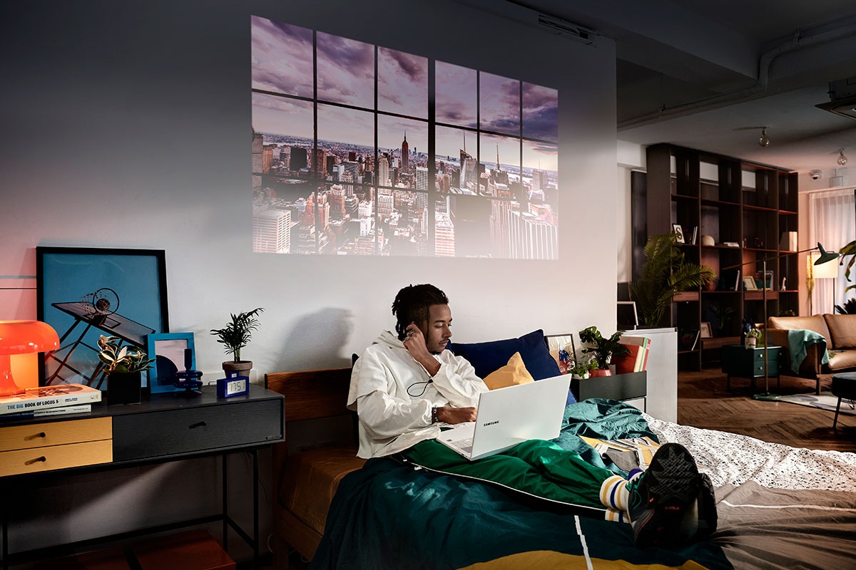 The Freestyle casts a fake window above a man working on his computer in bed. 