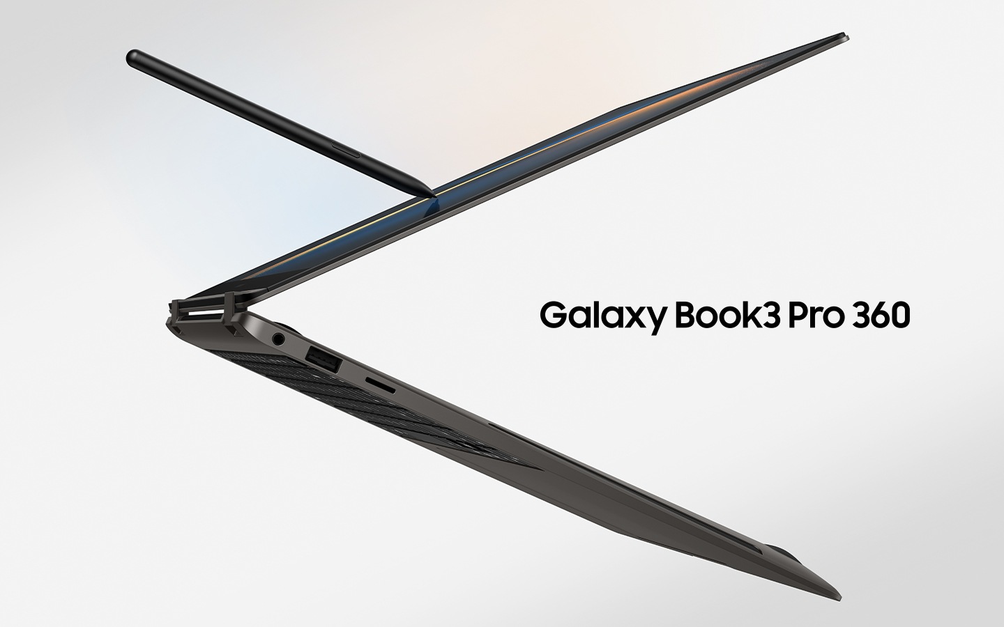 A graphite-coloured Galaxy Book3 Pro 360 is folded slightly back, facing left and an S Pen touching the screen.