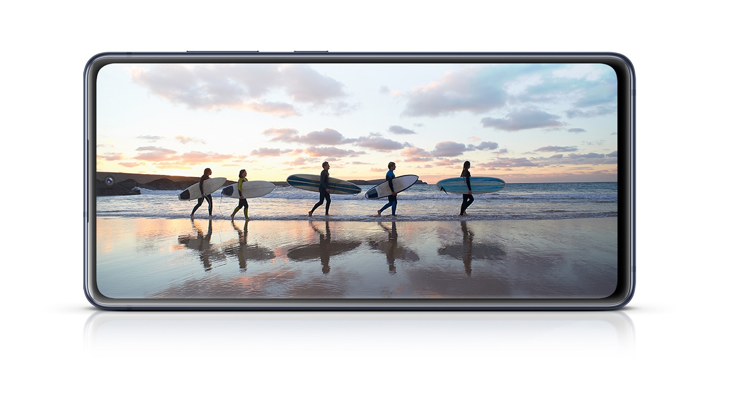 Galaxy S20 FE with a photo of surfers onscreen, showing the immersiveness of the Infinity-O Display.