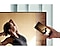 Un utilisateur place son smartphone contre son téléviseur AU7000 pour refléter le contenu de sa ballerine sur un écran plus grand pour plus de confort.