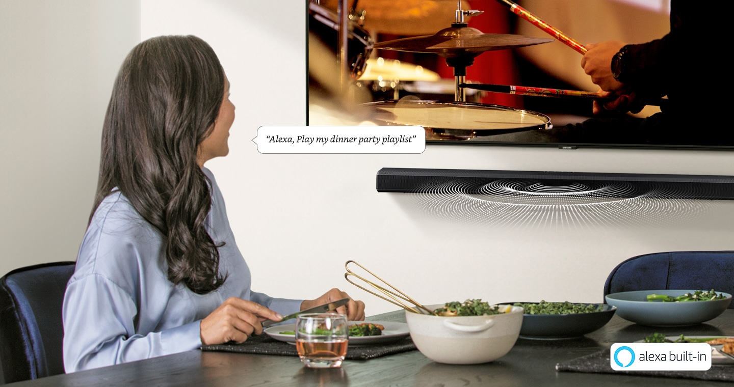 A woman uses Soundbar's built-in Alexa voice assistant and asks it to play her dinner party playlist.