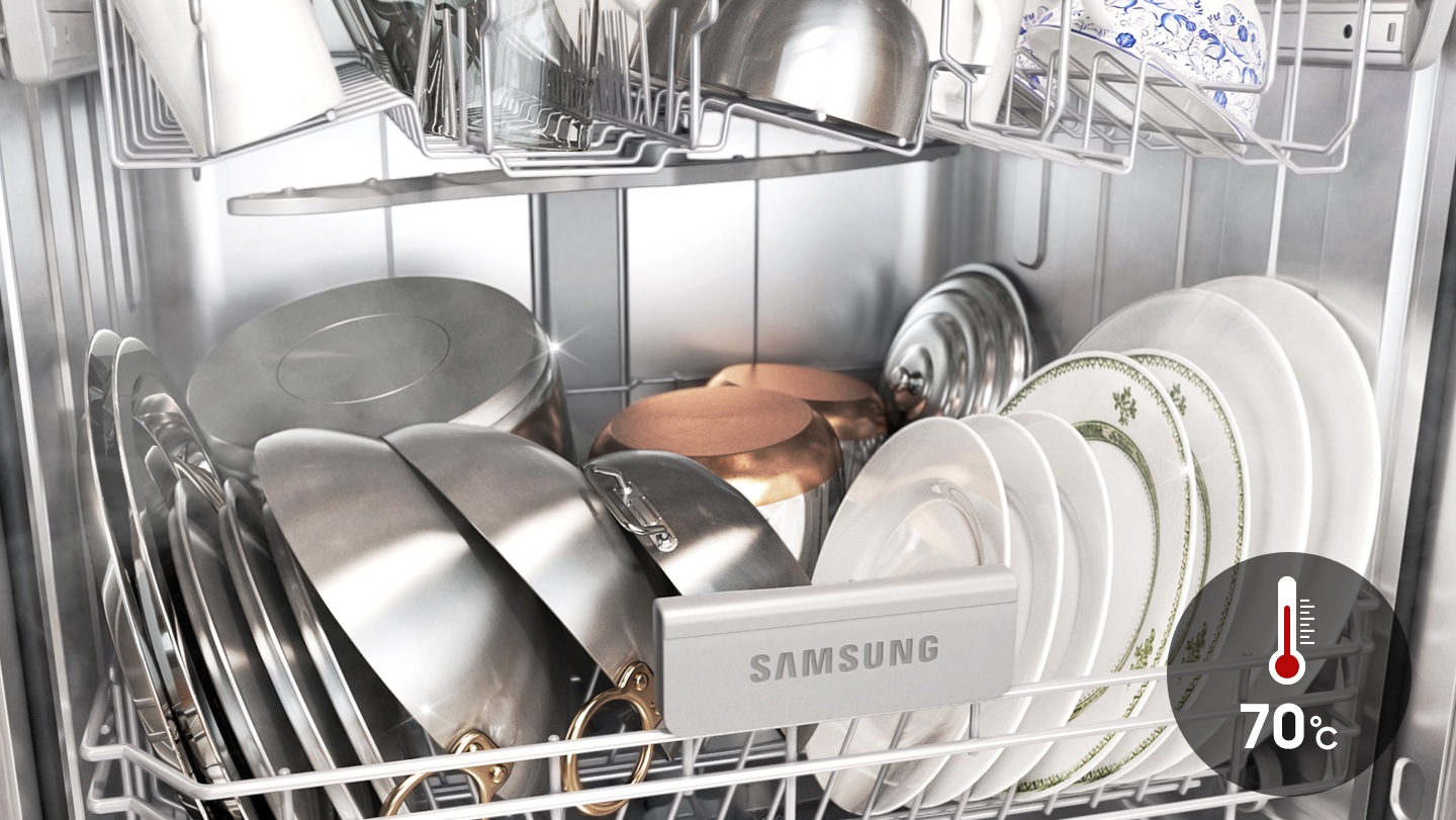 Shows a dishwasher full of cookware, plates and cups that have been cleaned at 70˚C to remove grease, oil and baked on food.