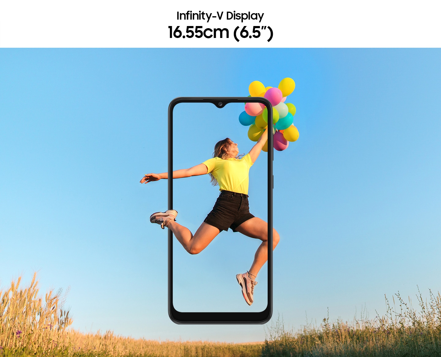 A girl is jumping up with a bundle of balloons in her hands, with the wide open sky in the background. The Galaxy A03 Core's large screen frames her entire body, with her foot and part of her calf outside it.