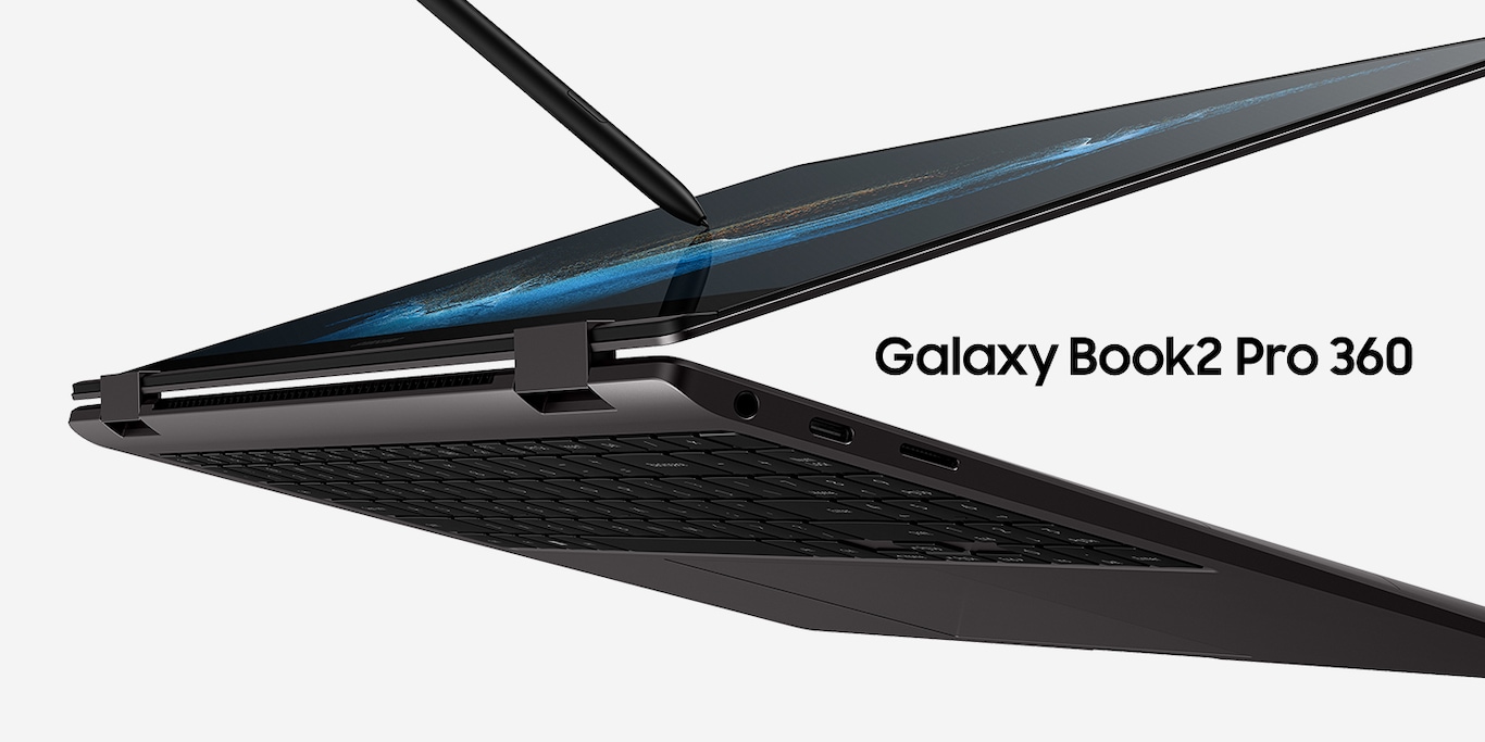 A graphite-colored Galaxy Book2 Pro 360 is almost folded all the way back and there is a wallpaper with blue waves on the screen. An S Pen is touching the screen.