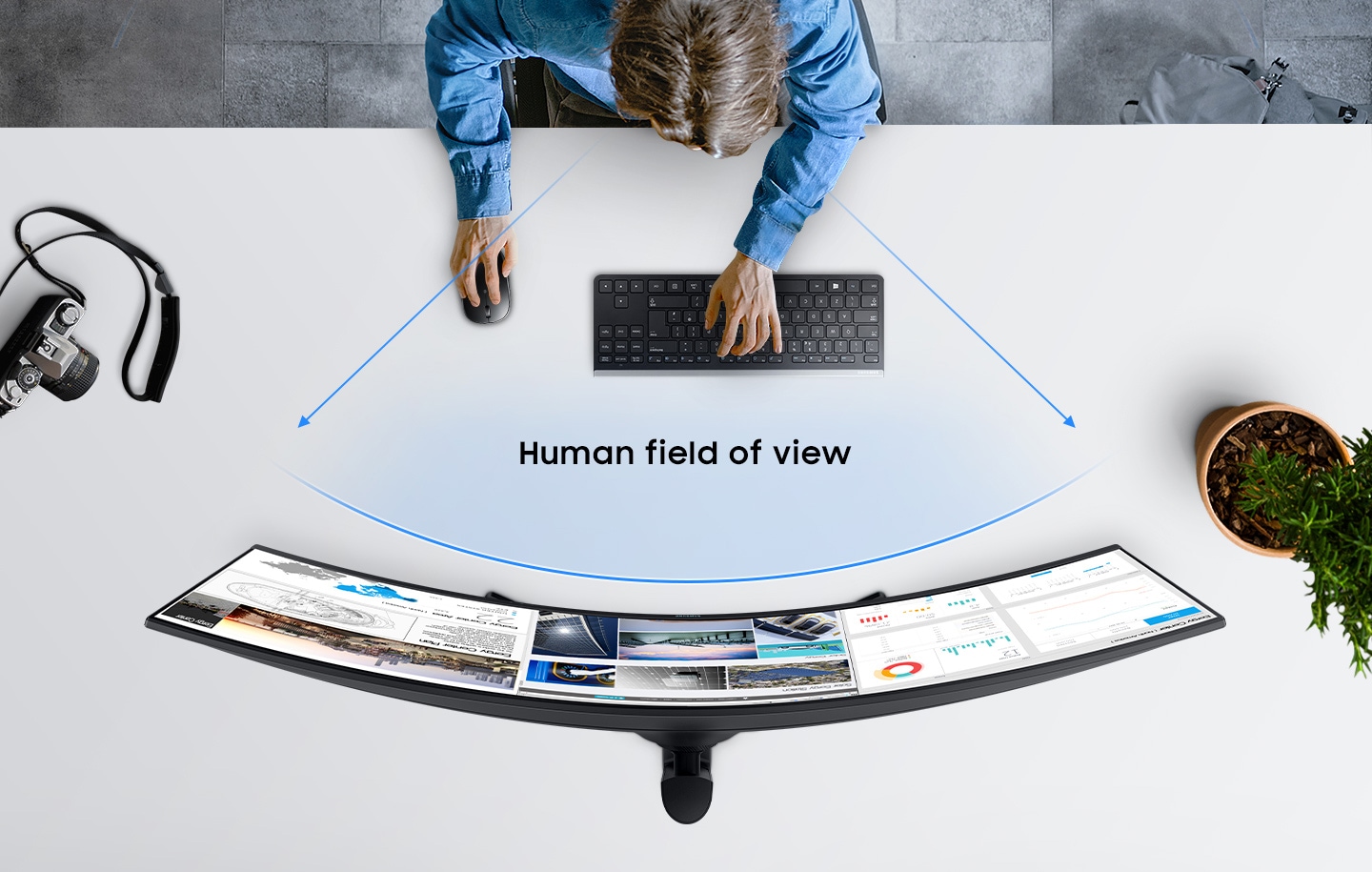 Birdseye view of S9 with an individual sitting in front of the monitor using a keyboard and mouse. Two gray beams of light are overlaid with the words 'Eye Fatigue Zone' while a blue curve shows the human field of view to demonstrate how the curved monitor matches the human eyesight. Also, on the desk either side of the individual using the monitor is a black digital camera and potted green plant.
