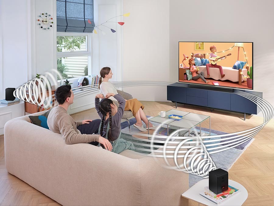 Family watches animation in immersive surround sound with Samsung Wireless Rear Speaker Kit and Soundbar activated together.