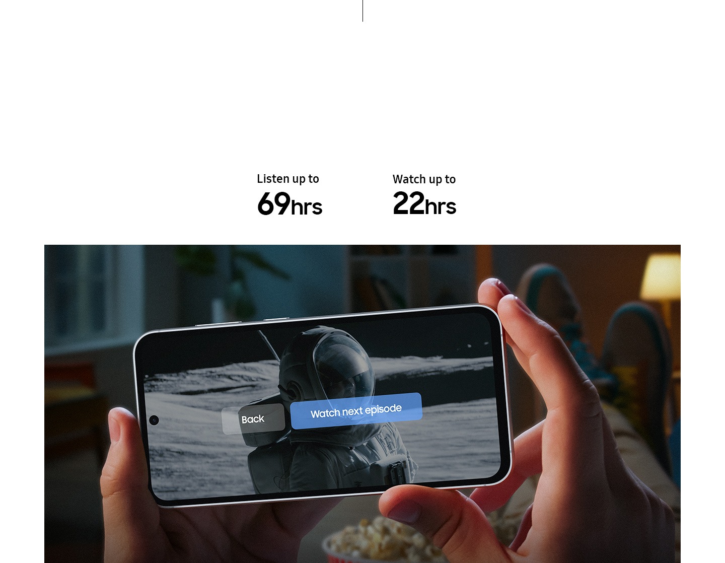 Two hands hold a Galaxy S23 FE device showing the end of a series onscreen. A subtitle reads watch next episode, back to highlight that the device has long-lasting battery. Text reads Listen up to 69 hours, Watch up to 22 hours.