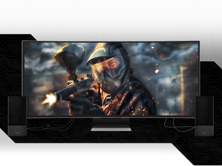 External speakers are connected on the left and right sides of the bottom of the Odyssey monitor. The screen shows a character playing paintball pointing a gun at the front.