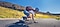 Longboarder is riding down a long, empty road while captured by the photographer who is also longboarding down behind. On the captured photo, a line down the screen divides the photo into left and right, which show the difference between stabilized and unstabilized shots. 
