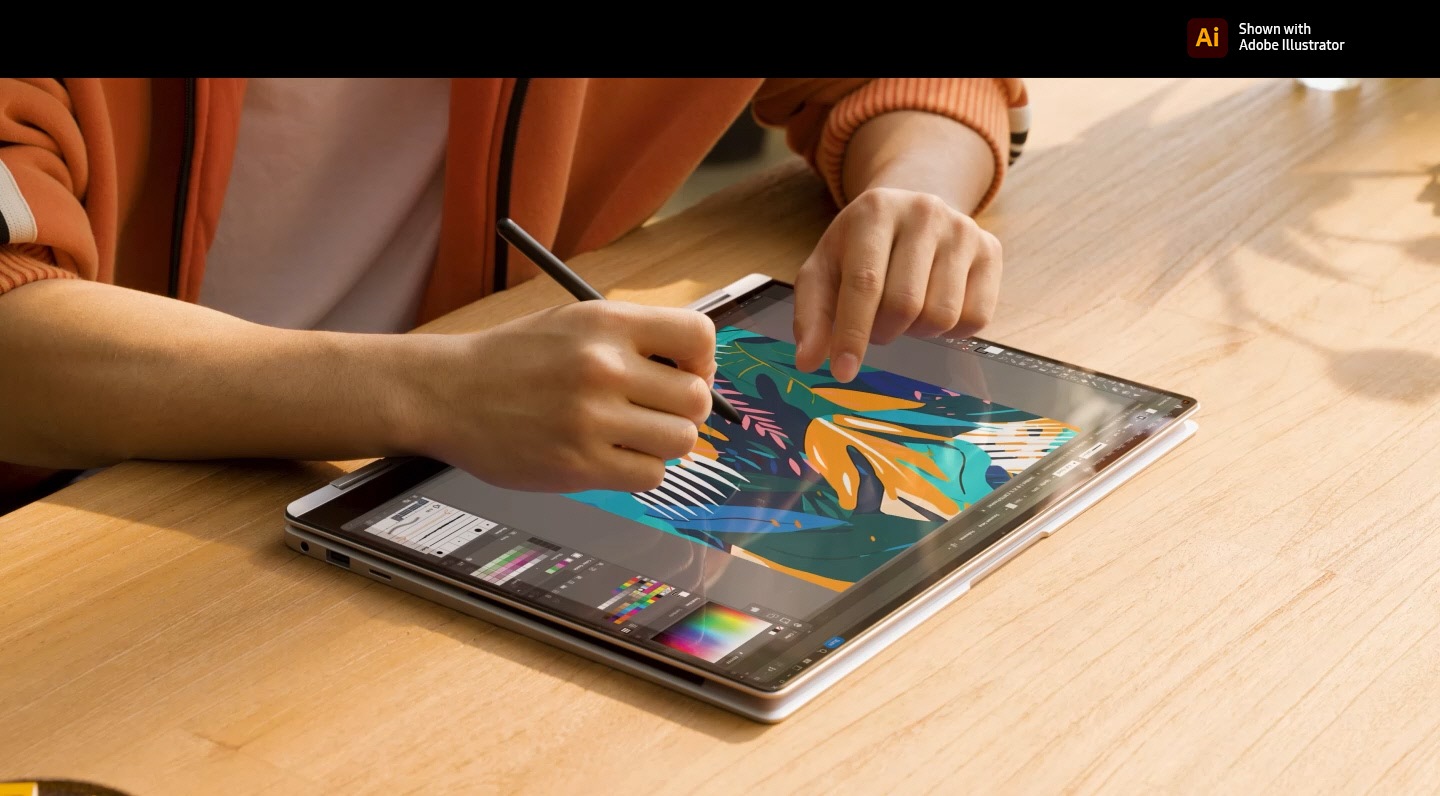 A person is using multi-touch gestures and S Pen to edit a colorful image open in Adobe Illustrator app onscreen on Galaxy Book4 Pro 360 in Platinum Silver, folded all the way back in tablet mode and placed on a table in a brightly lit studio. Adobe Illustrator logo is shown.