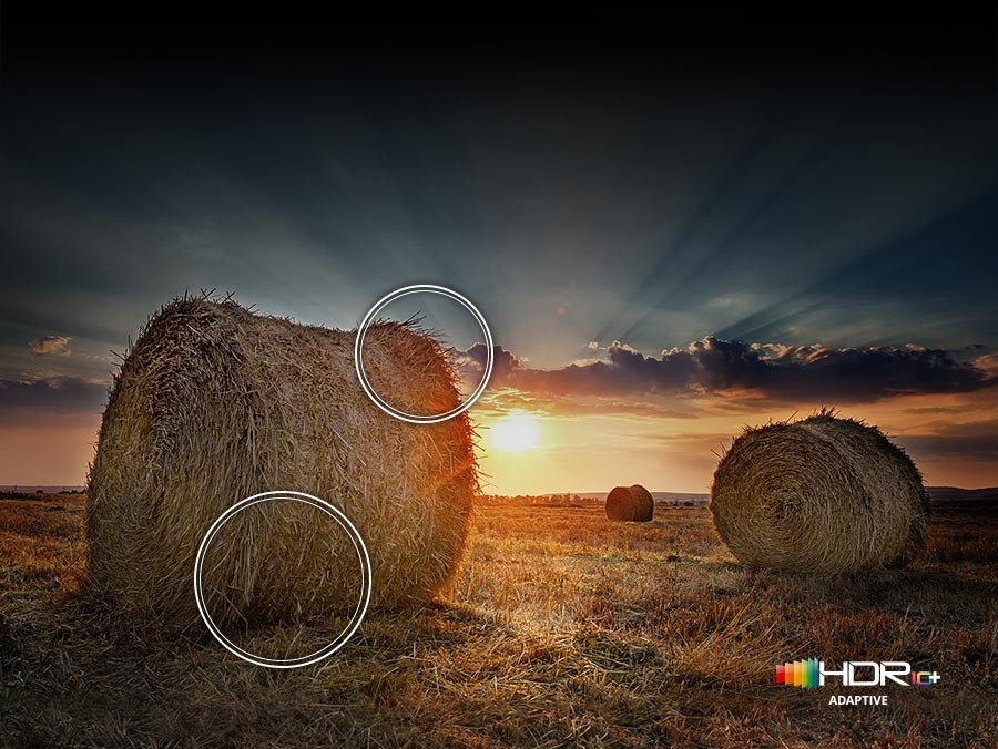The sun is setting over a wide field with emphasis on a large hay stack. The scene after applying HDR 10+ ADAPTIVE technology is much brighter and crisper than the SDR version.