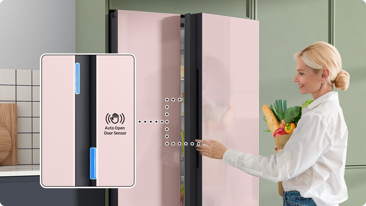 A woman with the food touches the auto open door sensor to open the refrigerator door. The doors have sensors on both sides.