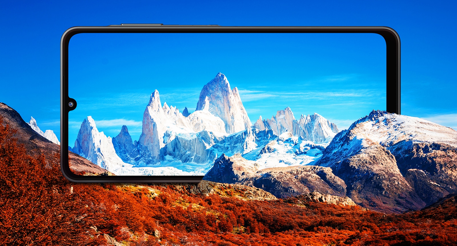 A large Galaxy A06 5G is positioned horizontally between rocky mountains. The screen frames the snowcapped mountains against a blue sky.