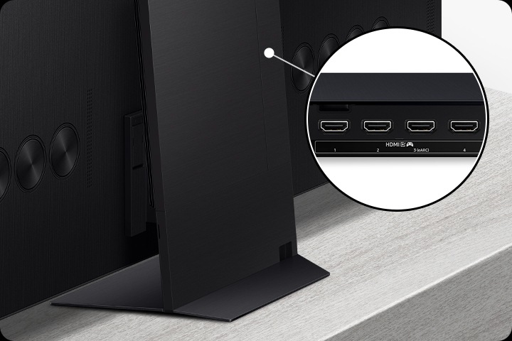 One Connect box attaches to the back of the TV stand. A close-up of the connection box shows 4 HDMI ports with a gaming icon and an eARC option.