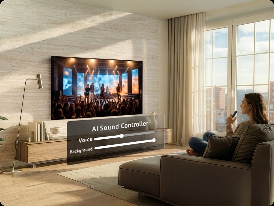 Woman watches musical performance on a Samsung TV. Below it, AI Sound Controller shows volume levels for the audio as two separate tracks: Voice and Background. As she speaks into the remote control ‘I want to hear the singing louder’, it adjusts to increase Voice and reduce Background.