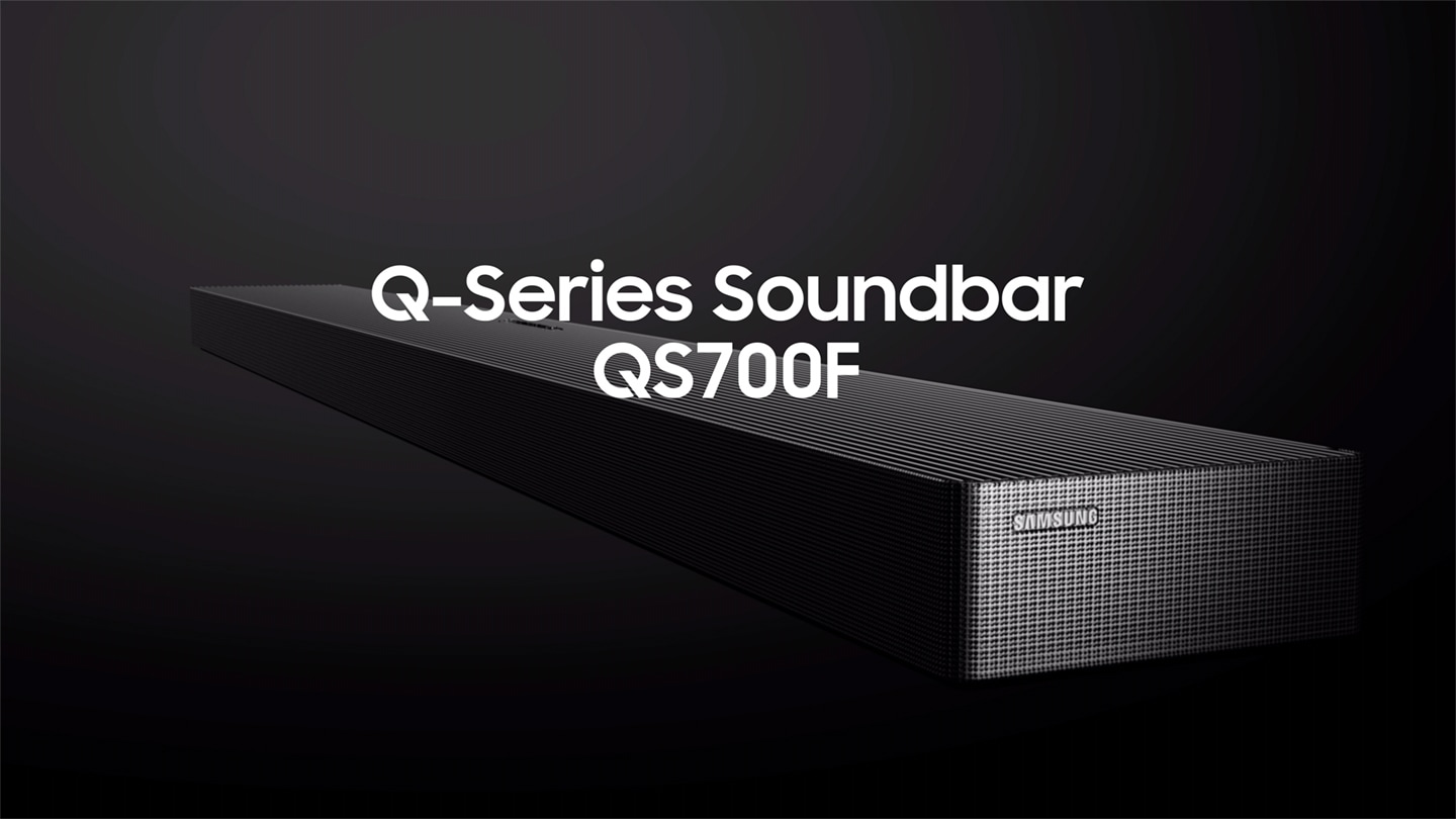 Samsung presents Q-Series Soundbar QS700F. QS700F placed on a media cabinet below TV in a room. QS700F inner components show how True 3.1.2ch sound is created. Completed audio environment for a captivating entertainment experience. Subwoofer inner components are shown. 6.5-inch active unit with 8-inch passive radiator. Soundwaves play from subwoofer, and then from soundbar as well. With Convertible Fit, QS700F is turned around and mounted to the wall below the TV. The gyro sensor ensures optimized surround sound no matter how you place it, table-top or wall-mount. Cable between TV and soundbar disappears to show how Wireless Dolby Atmos with Dolby Atmos logo plays immersive sound without an HDMI cable. TV & Soundbar speakers work together in perfect harmony with Q-Symphony. SpaceFit Sound Pro analyzes the room for stunning sound automatically tuned and calibrated for your space. Adaptive Sound plays sound and dialogue optimized for your content. QS700F setup with TV. Samsung logo.
