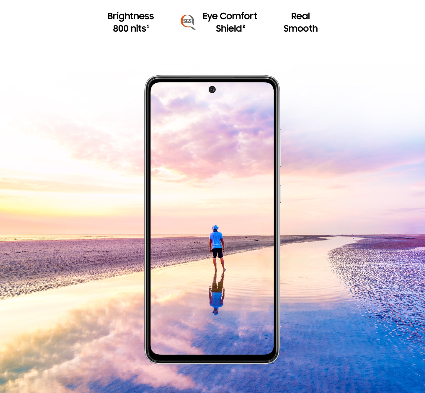 Galaxy A52 vu de face.  Une scène d'un homme debout sur une plage au coucher du soleil avec des couleurs roses et bleues dans le ciel s'étend en dehors des limites de l'affichage.  Le texte indique Brightness 800 nits, Eye Comfort Shield, avec le logo SGS et Real Smooth.