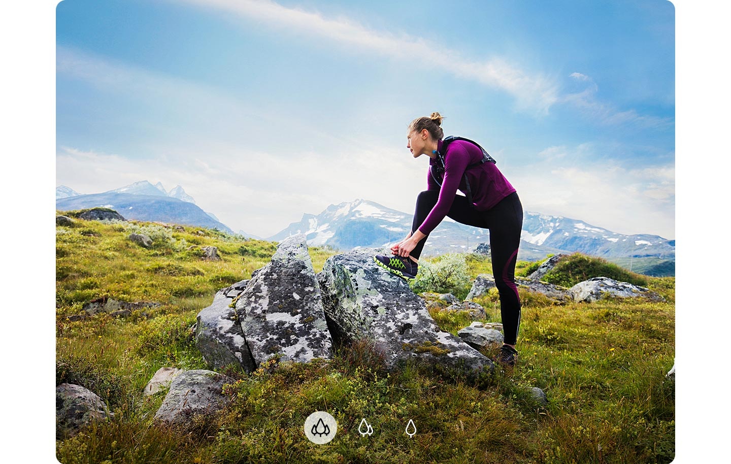 A woman staring at a distance with her foot on a rock and mountains shown in the background, indicating A72 can capture a wider image with Ultra Wide Camera.