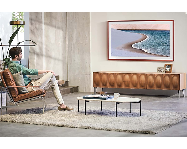 A man enjoys the ocean beach image on his living room the Frame TV.