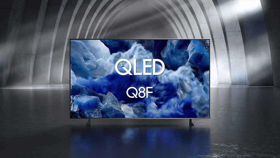 تەلەفزیۆنی Samsung QLED Q8F لە شوێنێکی ناوەوەی ڕەش و سپیدا دیمەنێکی ڕەنگاوڕەنگی سروشتیی جیهانێکی تر پیشاندەدات.