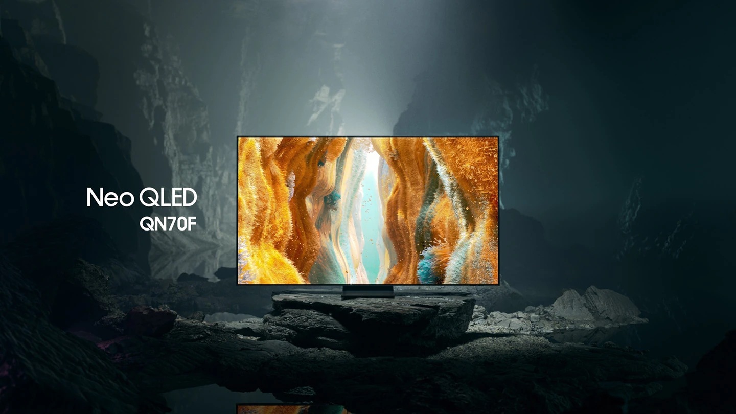 Samsung Neo QLED QN70F TV in a black and white underground space displays a colorful scene of an otherworldly landscape.