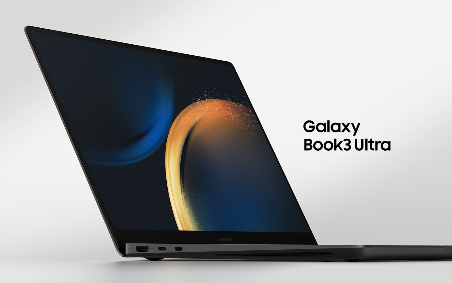 A graphite Galaxy Book3 Ultra is opened, facing slightly right with a black wallpaper onscreen.