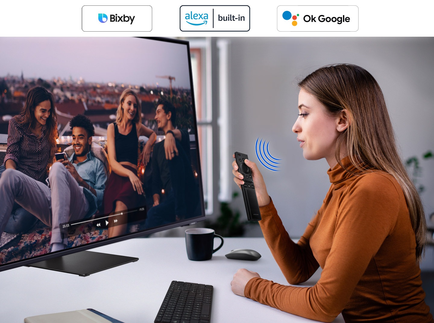 A woman speaks to the monitor. And a video is played on it. The Bixby and SmartThings icon is in the right corner.