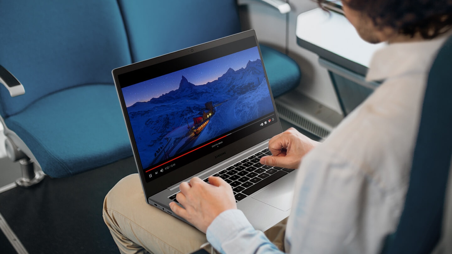 A person using Galaxy Book Go on a train. A video is playing on the screen.