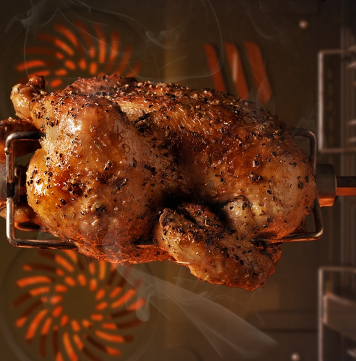 Shows a chicken turning on the Rotisserie as it is roasted evenly by the surrounding heat.