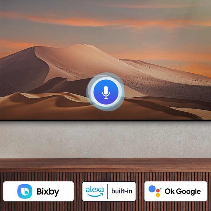  L'icona di un microfono si sovrappone a un'immagine, a dimostrazione della funzionalità dell'assistente vocale. I loghi Bixby, Alexa built-in e OK Google sono visualizzati in basso.