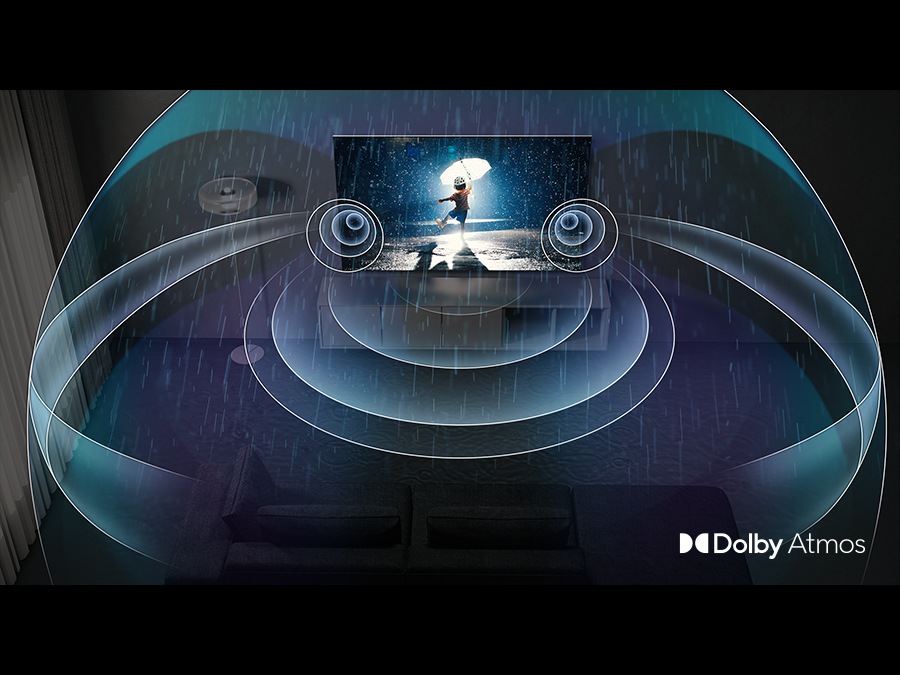  Una TV QLED mostra un bambino che gioca sotto la pioggia. Le onde sonore di Dolby Atmos escono dalla TV riempiendo la stanza.