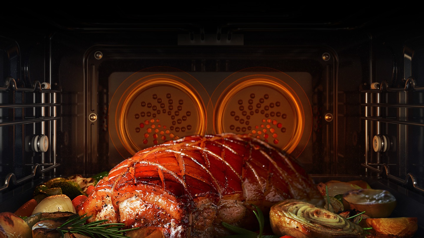 Mostra un arrosto di carne e verdure varie che vengono arrostite nel forno con doppie ventole nella parte posteriore che fanno circolare il calore in tutta la cavità del forno.
