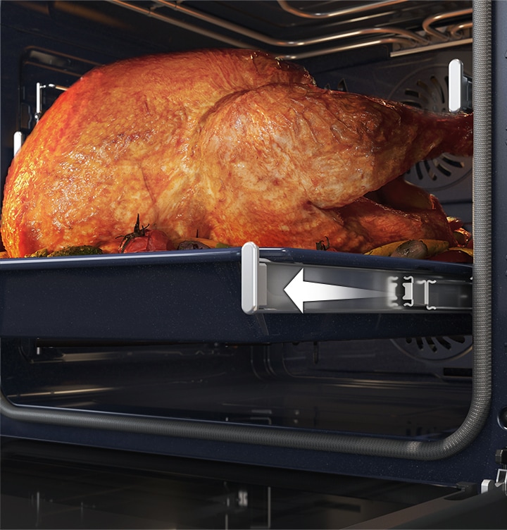 Mostra un grande tacchino arrosto che scivola fuori dal forno sulla guida telescopica.