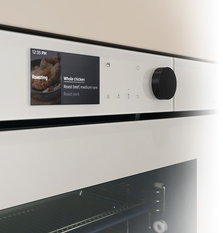 Shows a close-up of the oven's stylishly minimalist control panel with an LCD display, which shows pictures of the various cooking options, touch control and a single knob.